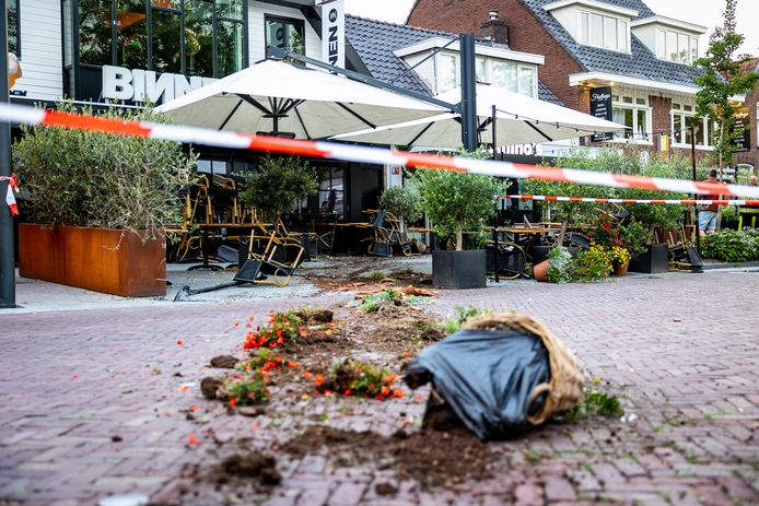De auto reed over het terras van Binnen, tegen de gevel van buurman Domino's.