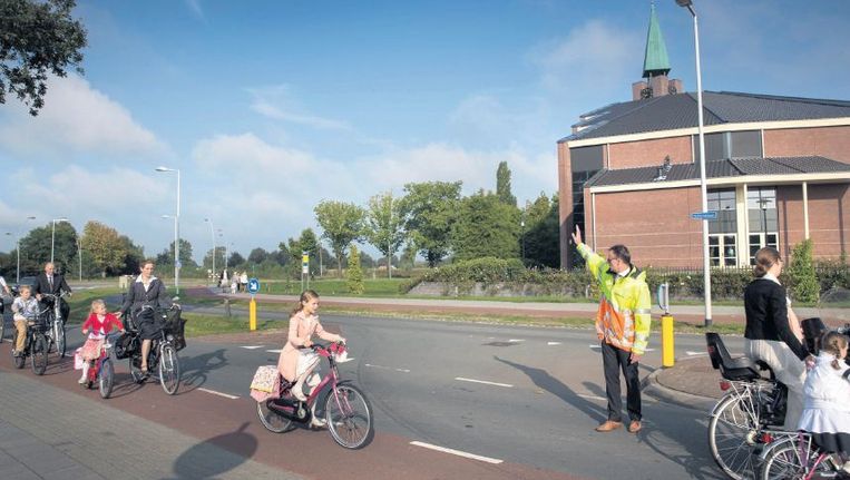 Op weg naar een kerkdienst in de Hoeksteen in Barneveld. De toeloop naar de 'refodome' - de kerk heeft 3500 leden - is zo groot dat er verkeersregelaars worden ingezet. Beeld Werry Crone