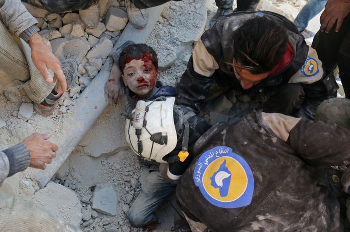 De White Helmets redden een jongetje vanonder het puin na een bomaanslag in Aleppo.