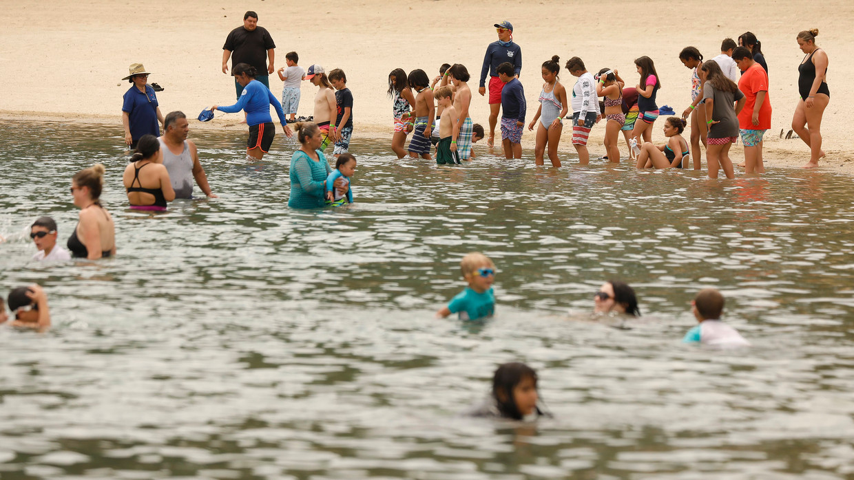 Mensen zoeken verkoeling in Castaic Lake Lagoon in Californië. Beeld Photo News