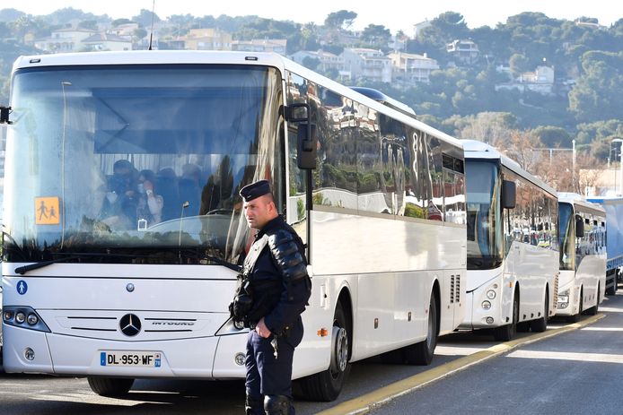 Een gendarme kijkt toe hoe bussen met uit Wuhan geëvacueerde Fransen langsrijden op weg naar het Vacanciel Holiday Resort in Carry-le-Rouet, in de buurt van Marseille, waar ze twee weken in quarantaine worden geplaatst.
