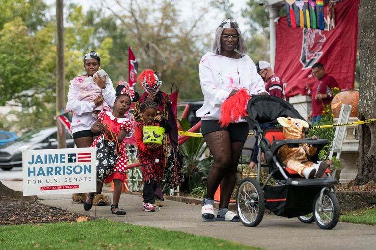 Kinderen gaan op jacht naar snoep – ‘Trick or treat’ – in Columbia, South Carolina. Jaime Harrison is daar kandidaat voor de Senaat. Beeld Getty Images