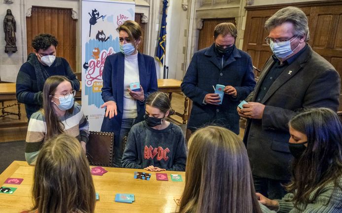 Onder het goedkeurend oog van de burgemeester en enkele schepenen spelen jongeren van het Voorlopig Bewind het kaarten spel 'De Geknipte Kat'.