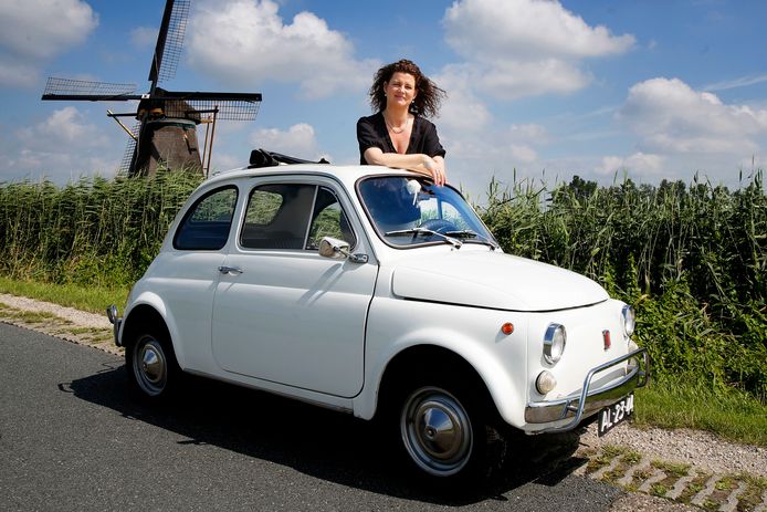 Rianne in haar Fiat, met op de achtergrond de molen waar haar vader is geboren.