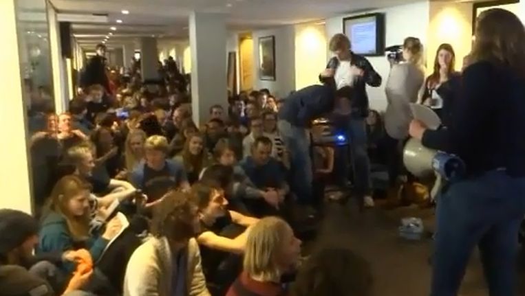 Een sit-in in de gang van het College van Bestuur van de Vrije Universiteit in Amsterdam. Beeld Still van video Actiegroep Titanic 