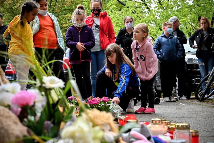 Kinderen uit de buurt komen afscheid nemen van de slachtoffers met bloemen, kaarsen en speelgoed.