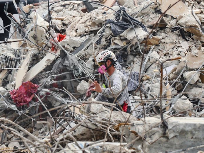 Een reddingswerker zoekt tussen het puin naar overlevenden.