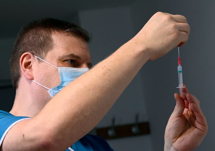 Een verpleger prepareert een vaccin.
