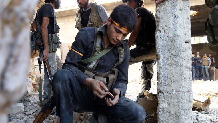 Een oppositiestrijder laadt zijn wapen in Ramosa, ten zuidwesten van Aleppo. Beeld afp