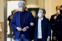 De Amerikaanse oud-president Bill Clinton (links) verlaat aan de zijde van zijn vrouw Hillary het ziekenhuis in Orange, Californië.
