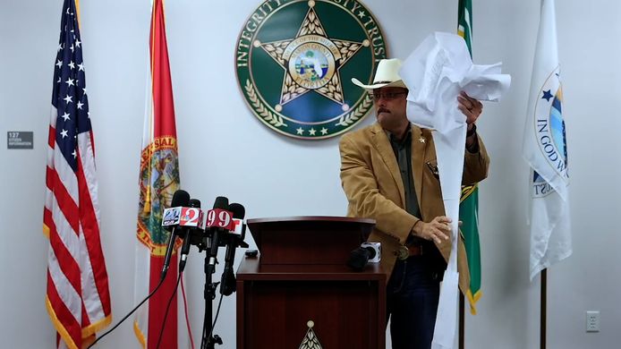Sheriff Billy Woods toont de “waslijst aan veroordelingen” op de persconferentie.
