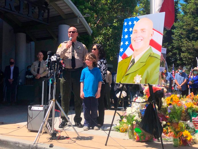 Santa Cruz Sheriff Jim Hart staat samen met vrouw en kind bij agent Damon Gutzwiller, die werd doodgeschoten door Steven Carrillo.