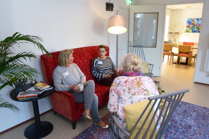 Gastvrouwen Margriet en Tineke (op de bank) maken een praatje met een bezoekster van Inloophuis Poppy's.