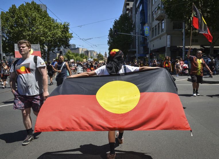 Protest in Melbourne tegen Australia Day op 26 januari 2019 met de Aboriginal-vlag. De dag is voor veel inheemse Australiërs omstreden. Beeld Anadolu Agency via AFP