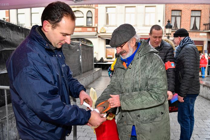 De bedeling van de polsbandjes begint. Pierre Annerel zat donderdag als eerste aan de Grote Markt en krijgt het eerste bandje.