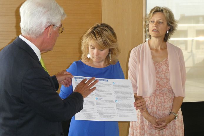 Burgemeester Jan Pommer (links) en Karin van Esch, directeur publieke gezondheid GGD bieden burgemeester Marieke Moorman van Bernheze de leidraad met checklist aan voor de aanpak van verwarde mensen. Moorman is voorzitter van de Vereniging Brabantse Gemeenten.