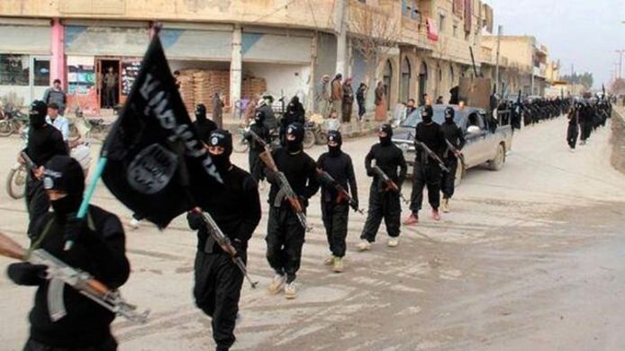 IS-strijders trekken door de straten in Raqqa, tot medio 2017 de hoofdstad van het kalifaat.