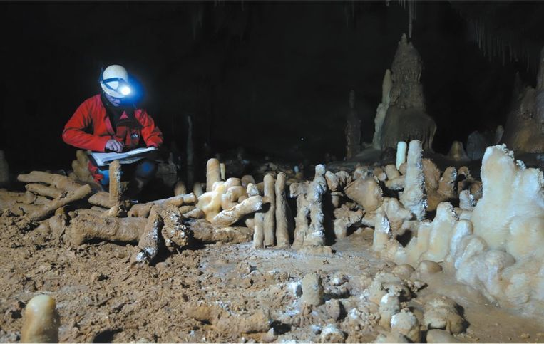 Archeoloog aan het werk bij een gestapelde structuur in de Neanderthalergrot van Bruniquel. Beeld Caussade-Speleo