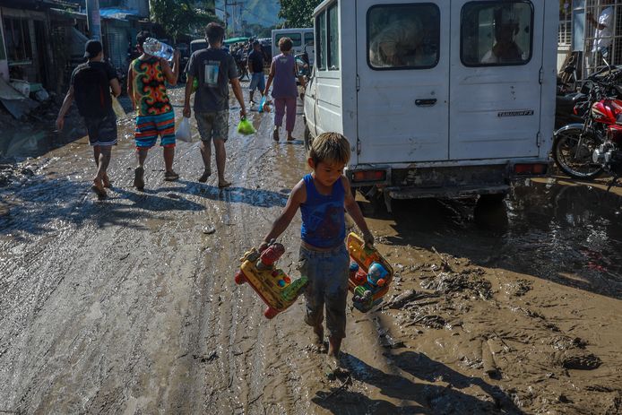 Een jongetje met zijn uit de modderstroom gered speelgoed in Rodriguez ten oosten van Manilla.