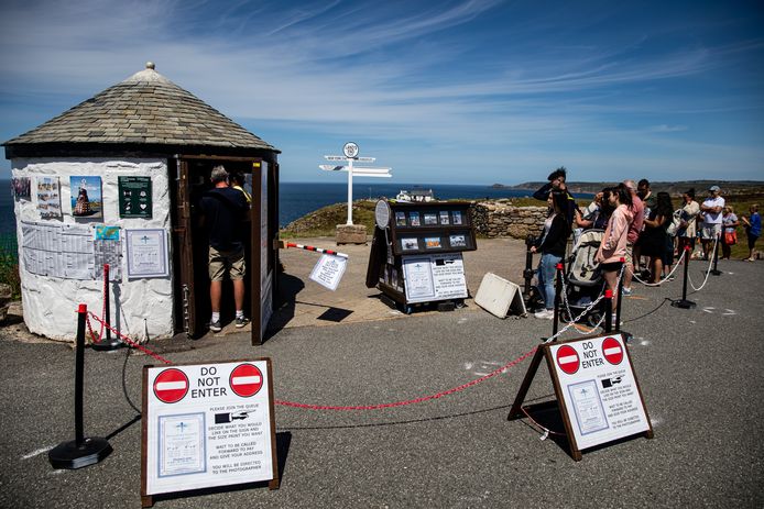 Toeristen respecteren de sociale afstand terwijl ze aanschuiven in Cornwall.