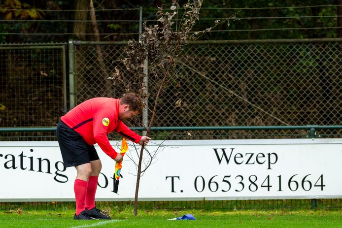Hilariteit in Hattemerbroek, waar de cornervlag is vervangen door een dode tak. De grensrechter van ’t Harde speelt zijn rol als hovenier vaardig.