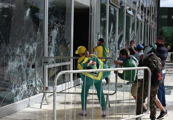 Bolsonaro-aanhangers vernielen een raam van het Hooggerechtshof in Brasilia.