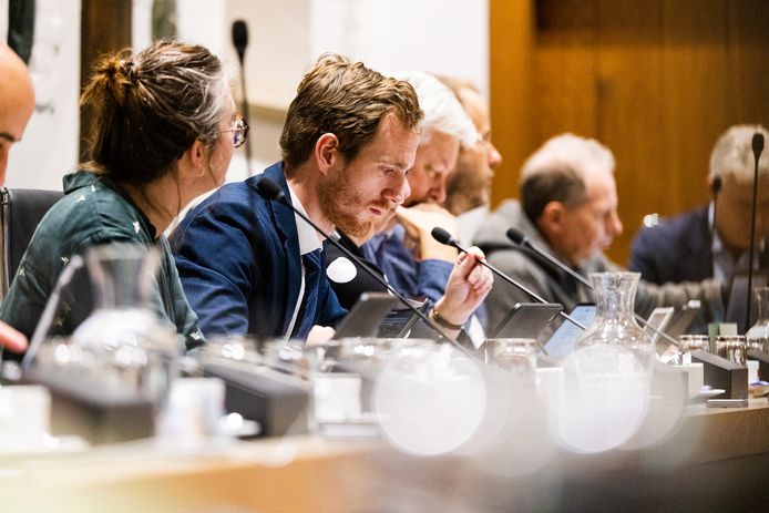 Jan van Dam Timmers (CDA) houdt de microfoon vast tijdens een gemeenteraadsvergadering in het stadhuis.