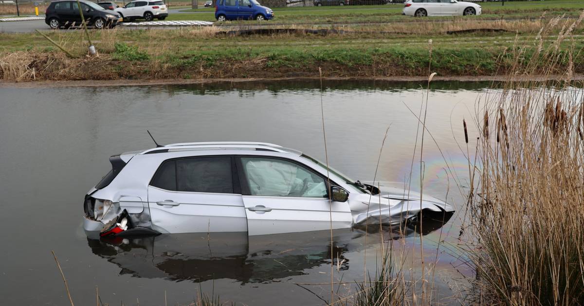 Grote schade bij botsing tussen autos in Waalwijk: brokstukken op de weg, auto belandt in water.