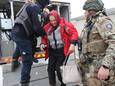 Oekraïense hulpverleners evacueren een oudere vrouw in Vovchansk.