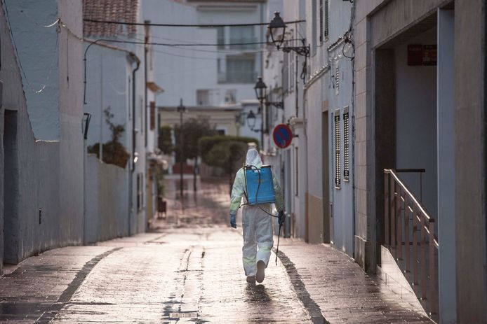 Een stadsmedewerker desinfecteert de Spaanse verlaten straten.