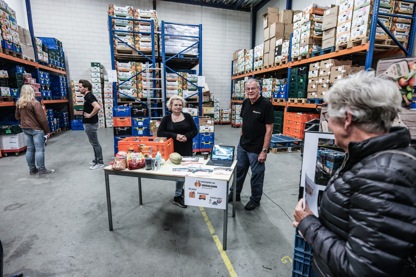 Vrijwilligster Anja Nieuwenhuis (midden) en Peter Bob Peerenboom verwelkomen mensen die een kijkje komen nemen bij Voedselbank Doetinchem.