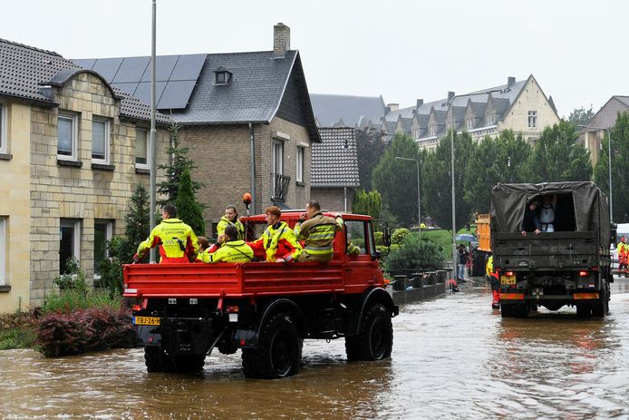 Reddingswerkers en militairen helpen in Valkenburg mensen uit hun huizen.