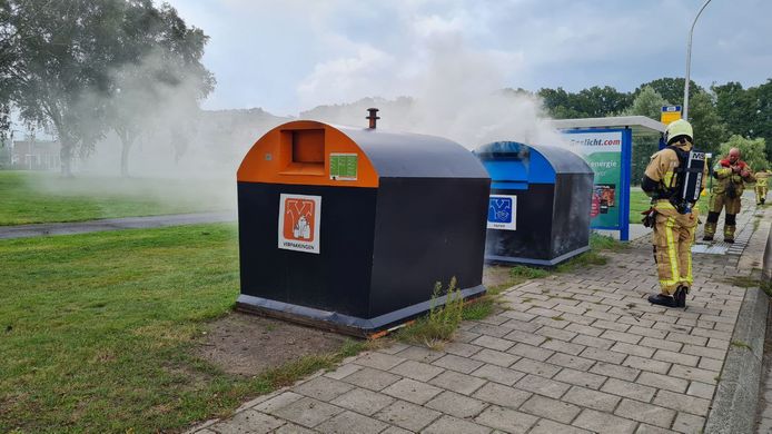 De brandweer blust de papier- en plasticcontainer.