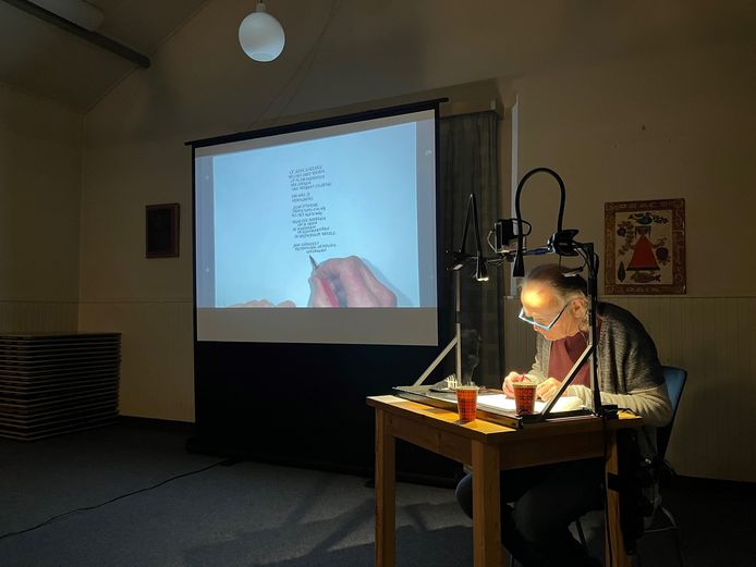 Woordkunstenaar Miesjel van Gerwen in stilte aan het werk terwijl hij met slechts een paar kernwoorden een gedicht over een overledene schrijft.