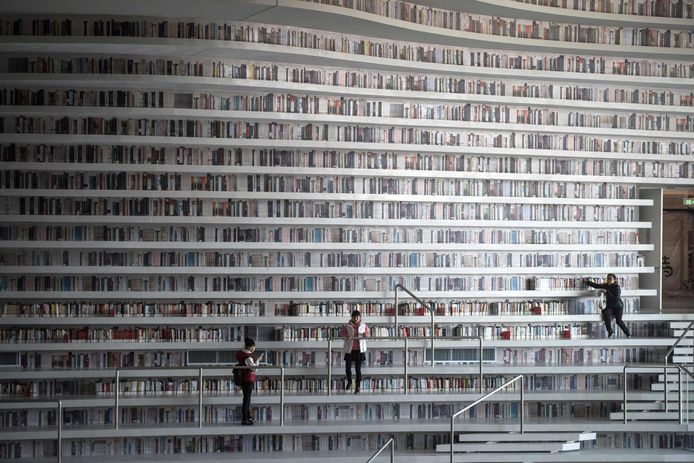 Bezoekers bladeren door boeken in de enorme bibliotheek.
