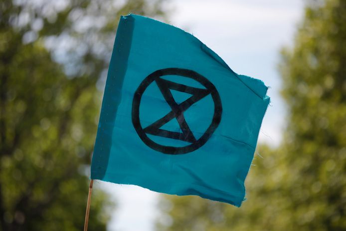 Een vlag met het logo van Extinction Rebellion.