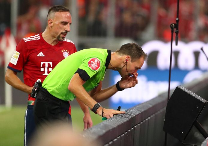 Franck Ribéry kijkt stiekem mee over de schouder bij Bastian Dankert.