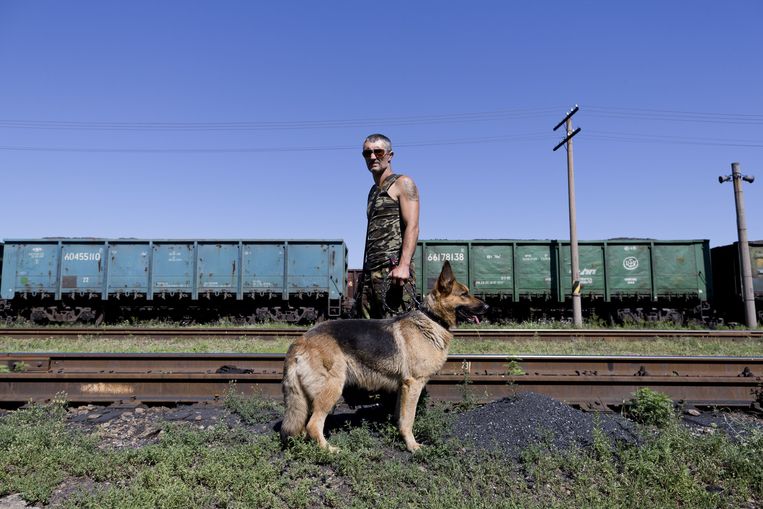 Een pro-Russische rebel bewaakt het station van Torez waar een trein met vier koelwagons met lichamen van slachtoffers van de vliegramp in Oekraine klaar staat om te vertrekken. Beeld anp