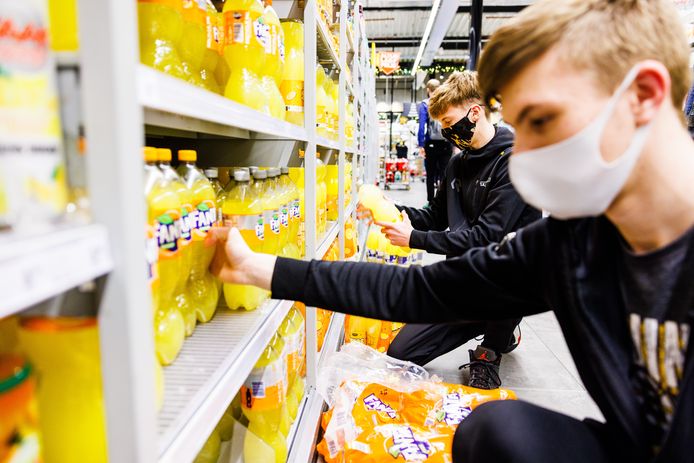 Ter illustratie: jongeren aan het werk bij een Jumbo-supermarkt. Het zijn jeugdspelers van een voetbalclub die niet meer konden trainen en dan maar de supermarkt uit de brand hielpen.