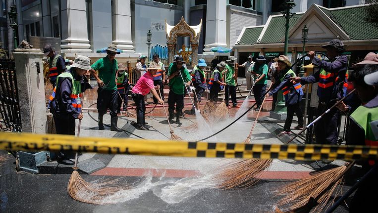 Stadsschoonmakers maken de plek van de aanslag schoon, zodat iedereen in Bangkok snel weer kan doen alsof er niets is gebeurd. Beeld epa