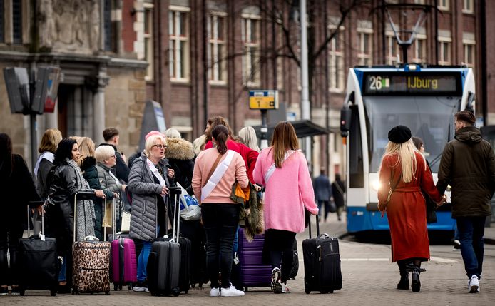 Toeristen met rolkoffers in het centrum van Amsterdam.