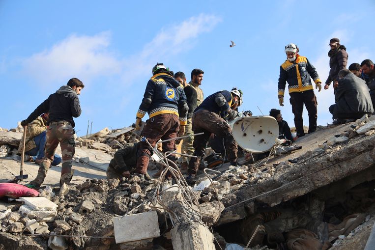 Syrische reddingswerkers op het puin van een ingestort gebouw tijdens een zoekactie in de stad Jandaris, in het door rebellen gecontroleerde deel van de provincie Aleppo. Beeld AFP