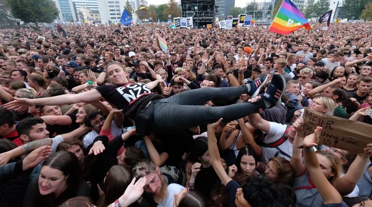 Een crowdsurfer tijdens een concert tegen racisme, xenofobie en geweld in de Duitse stad Chemnitz. Beeld Sebastian Willnow/dpa-Zentralbild/dpa