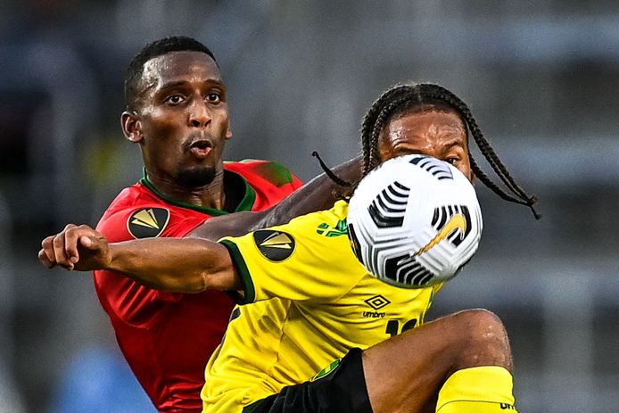 Bobby Reid (rechts), die de tweede treffer scoorde voor Jamaica, in gevecht met de Surinamer Dion Malone.