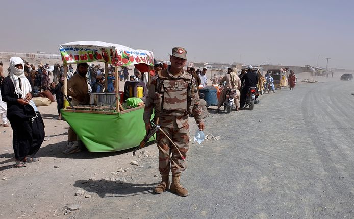 Een Pakistaanse soldaat houdt de wacht bij gevluchte Afghanen aan de gesloten grensovergang met Pakistan in de grensstad Spin Boldak, in de zuidelijke provincie Kandahar.