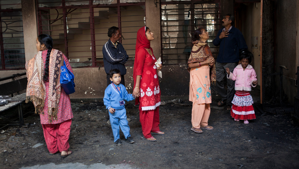 Indiase christenen kijken naar het interieur van een kerk in New Delhi, die begin dit jaar afbrandde. De oorzaal is niet opgehelderd, maar brandstichting wordt vermoed. Beeld AP
