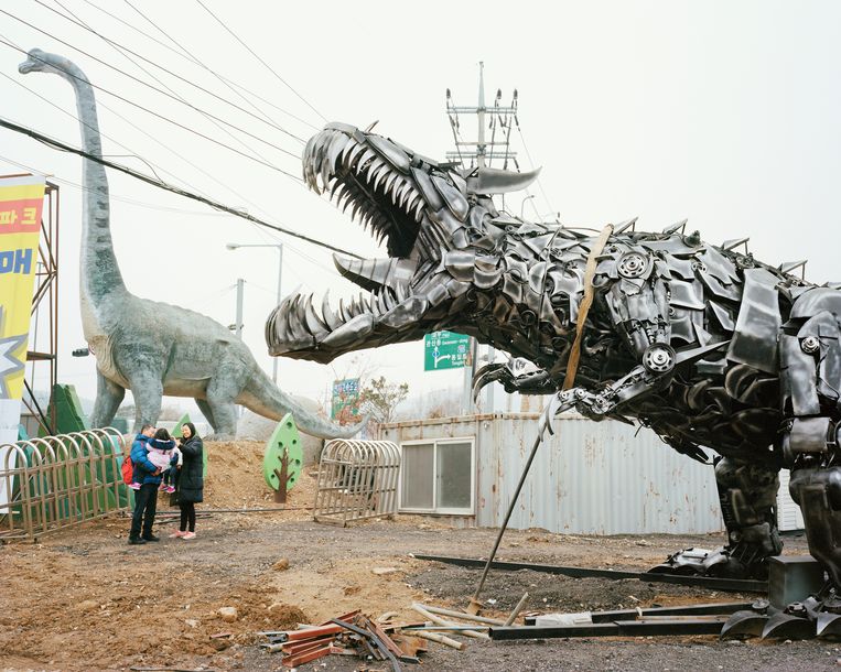 Aan het nieuwe dinosaurus­themapark wordt nog druk gewerkt, maar een jong gezinnetje komt alvast eens kijken.   Beeld Seunggu Kim/INSTITUTE