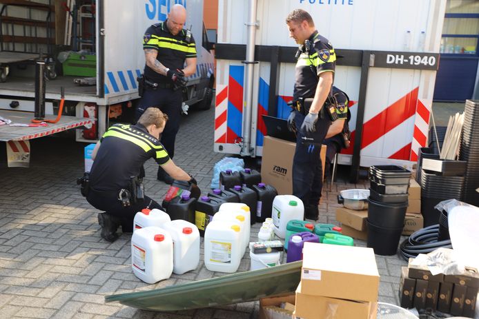 Politieagenten doorzoeken spullen afkomstig uit het pand aan de Cort van der Lindenstraat in Rijswijk.
