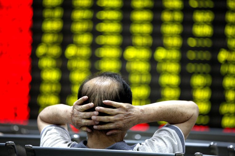 Een bezorgde Chinese investeerder volgt dinsdag de dalende koersen bij een effectenmakelaar in de stad Huabei. Beeld Xie Zhengyi/Imaginechina
