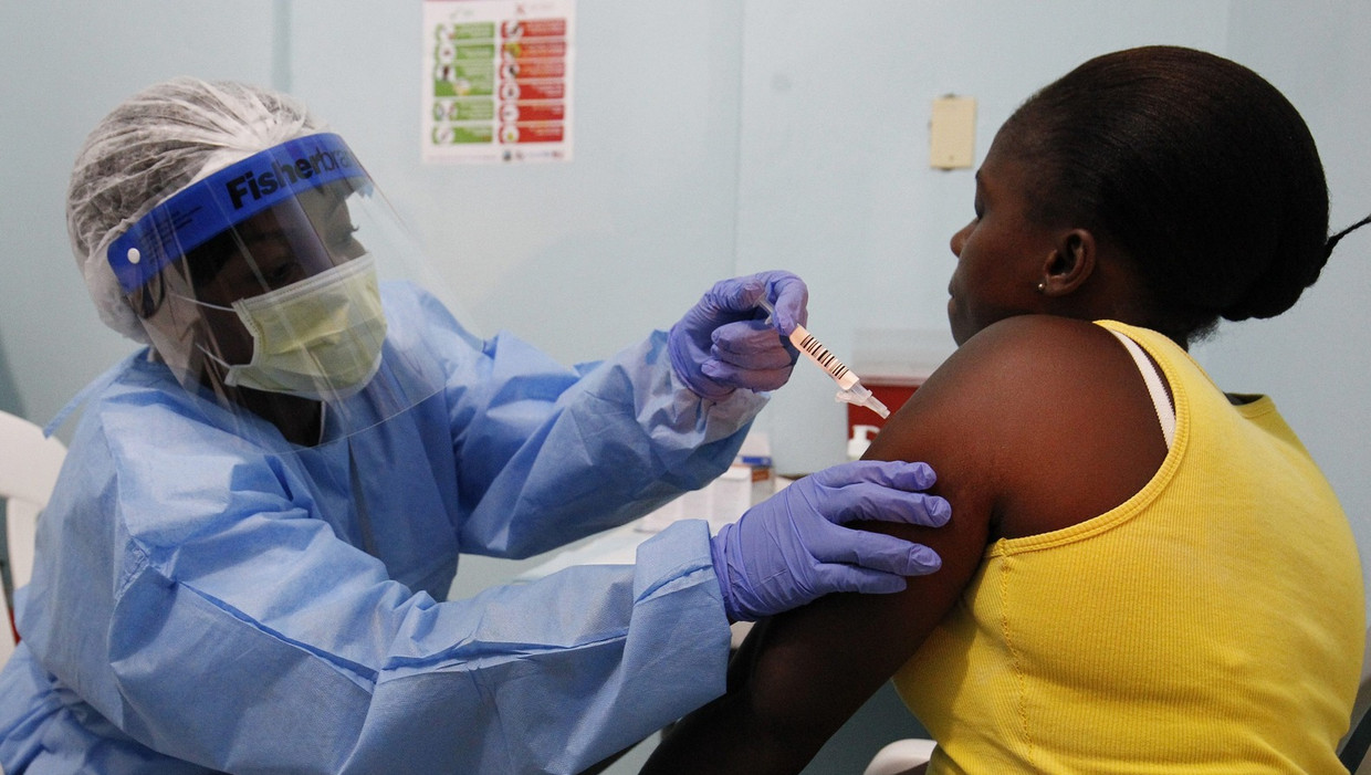 Een vrouw krijgt een experimenteel ebola-vaccin toegediend in het Redemption Hospital te New Kru Town, buiten Monrovia, Liberia. Beeld ANP